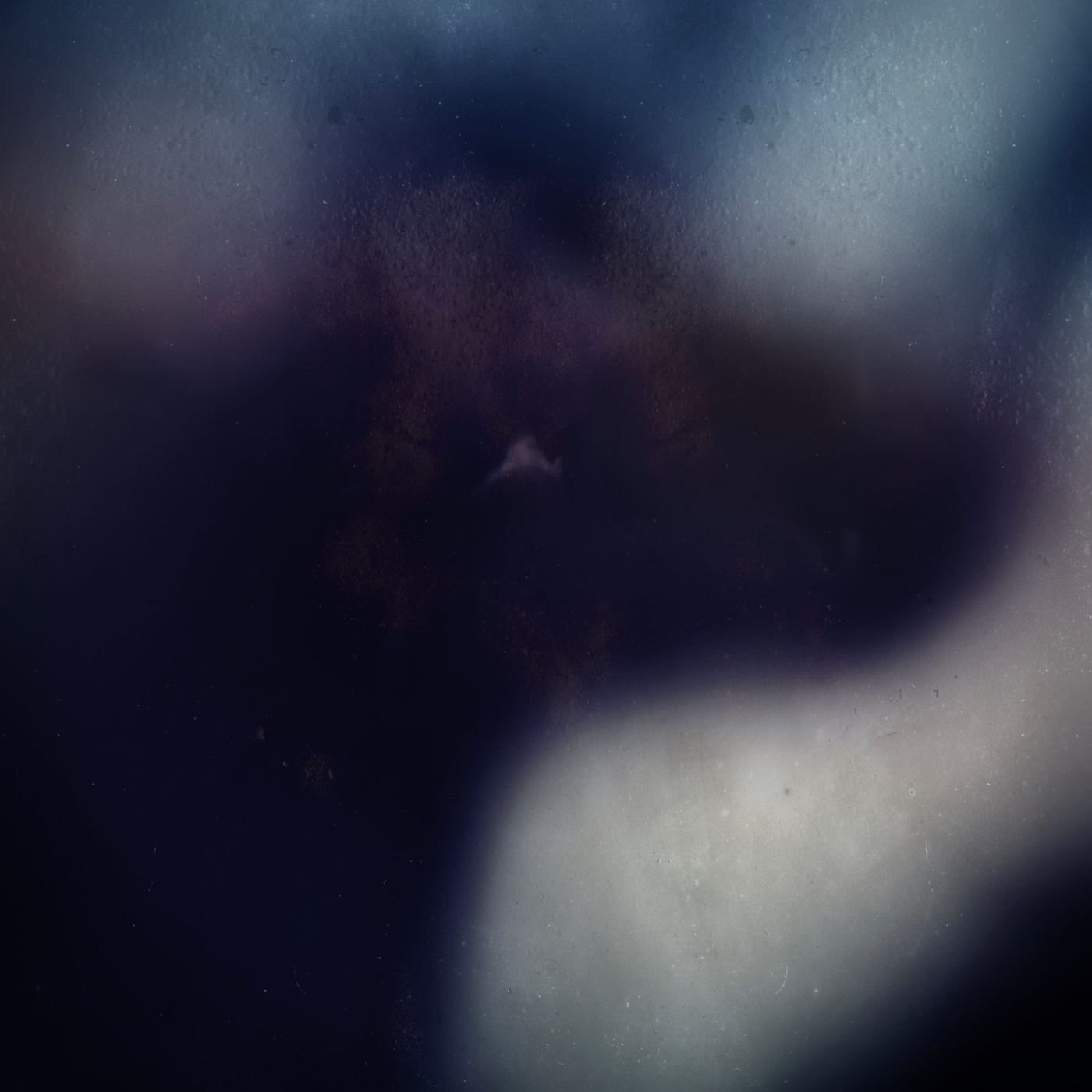 A dark field with a pale curve of light
